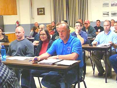 Lansing Fire Chief Scott Purcell (blue shirt, at front) was backed up by almost 30 Lansing Volunteer Fire Department members at Tuesday's Fire Commissioner's meeting. firechief_purcell