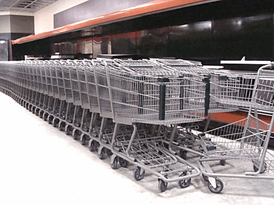 Shopping carts are currently stored at the back of the market, stretching from the dairy shelves to the 'beer cave'. lmaug_carts