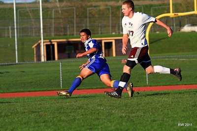Junior winger Ellington Hopkins watches his cross sail into the offensive box at Whitney Point on Monday. (Shown at top) Sophomore defender Jake Palladino follows through on his clearance during the Bobcats’ 15th consecutive victory. soccer_10wp_hopkins