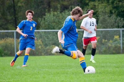 Junior Cobi Byrne rips a shot against Groton (Smaller picture above) Sophomore Benji Geisler avoids the Groton keeper on an attack to the goal soccer JuniorMFerCobiByrne400