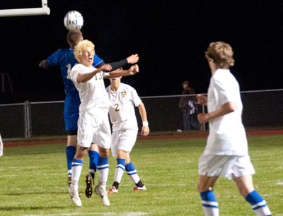 Junior defender Timmy Arleo challenges for a ball in the air while sophomore Benji Geisler (#2), and junior Cobi Byrne watch. soccer tburgarleo