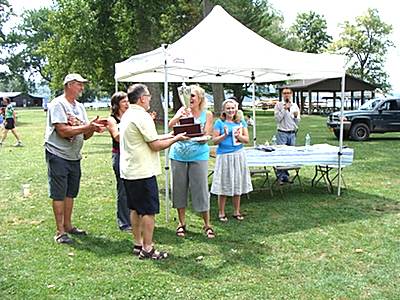 And the winner is... WHCU's Geoff Dunn presents the Baker Cup to winner Pam Silliman. Left to right behing them the other contestants applaud, Dave Hatfield, Katrina Binkewicz, and Amy Wayne bakercup_winner