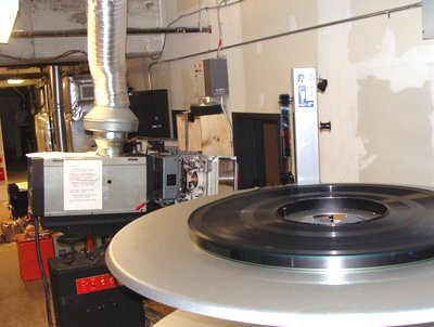 This movie came on eight smaller reels that were spliced together and placed on a giant spindle tray when they reached Cinemapolis. The film feeds through the projector and is wound onto another tray below. cinemapolis_35milimeter