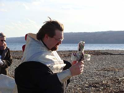 Fr Worthington just before tossing a cross made of ice and flowers into Cayuga Lake ha_icecross