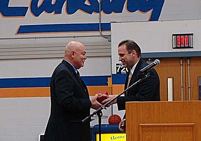Marty Christopher (left) receives a golden apple from Superintendent Stephen Grimm at Saturday's Athletic Hall of Fame Induction Ceremony mc_withgrimm