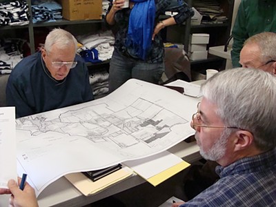 Sewer committee members look at a map of the potential sewer district showing three tiers of billing, including the initial service area, properties outside that area that currently fall in the water district, and properties outside the water district but inside the sewer district sewer_maplook400