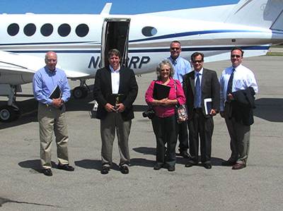 NRP Group flew (left to right) Lansing Economic Development Committee Chairman Andy Sciarabba, Better Housing of Tompkins County's Richard Cowan, Lansing Town Supervisor Kathy Miller (center), Town Engineering and Planning Coordinator Jeff Overstrom (behind Miller), and (left) to view existing developments in Wheatfield and Cleveland last week to show them examples of the kinds of projects they hope to build in the Lansing Town Center. At right are NRP Group's Ken Outcalt and Chris Derr. tc_nrpplane400