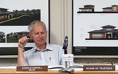 Mayor Donald Hartill (shown in front of building plans) Monday recommended rejecting bids for a new Village office building voffice1210_hartill