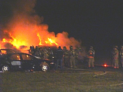Companies of firefighters are given a car fire to extinguish, using the skills they learned in the classroom in Ithaca over the past four months firetraining_flames