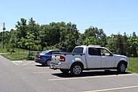 A parking lot and grassy area top the road -- designated as a walking path -- that leads to Poison Ivy Point pip_parking