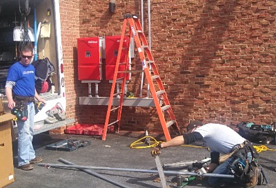 Installers preparing parts of a solar array located on the roof of TST BOCES Building C bocessolar_installers