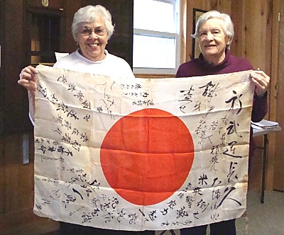 Fannie Welsh (left) and Louise Bement holding a Japanese national flag that they believe was signed by friends of a Kamikaze pilot to wish him well before his fatal mission hist_def_flag