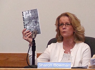 Sharon Bowman shows the new cookbook to the Lansing Town Board dish sharon