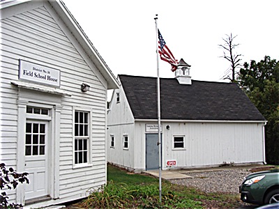 The Town Historical Records Building sits between the Field One-room School House (left) and the Lansing Community Center near the Town Hall and the Lansing Community Library Town Records Building