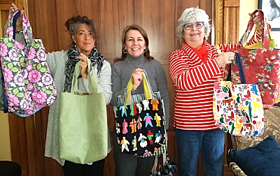 (Left to right): Kerry Quinn, Client Services Director at the Cancer Resource Center, Linda Van Nederynen of Quilters Corners, and Aafke Steenhuis, quilter and Cancer Resource Center client, display some of the beautiful donated tote bags. quilters