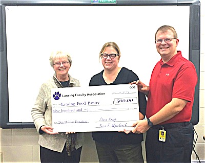 Lansing Faculty Association President Stacie Kropp and LFA Treasurer Kevin Wyskowski present funds donated by teachers, counselors, nurses, and teaching assistants to Lansing Food Pantry Director Nancy Myers. The LFA has donated over $5000 in the past several years to the Lansing Food Pantry. school LansingFacultyContinueTraditionofGivingBackToTheLansingCommunity