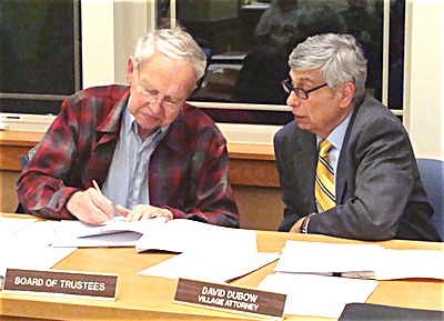 Mayor Donald Hartill signs the State Environmental Quality Review (SEQR) required for the new Comprehensive Plan revision, with Village Attorney David Dubow looking on. The Board of Trustees unanimously approved the SEQR and accepted the plan Monday. Village of Lansing
