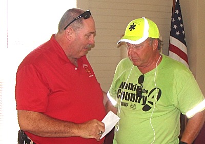 Dennis Griffin gives Allinger a donation that will feed three kids for a year of weekends. Walkin' The Country