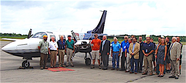 Local buseinessman Larry Baum (third from left) is joined by County and airport officials and well wishers after making the first landing Saturday after the runway was reopened. Runway Reopens