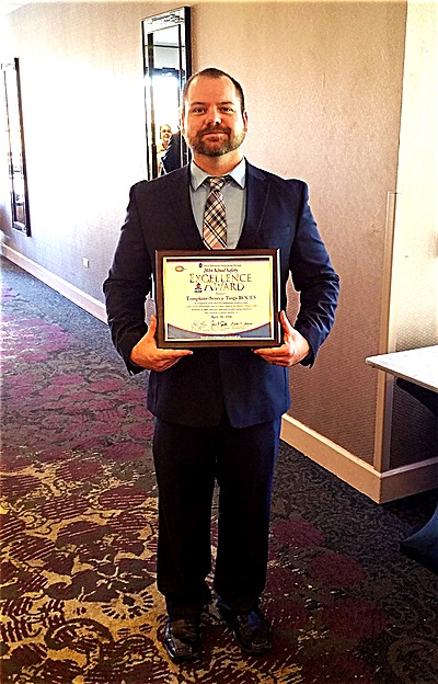Craig Griffin, Work Environment Health and Safety Assistant from TST BOCES, stands with the "School Safety Excellence Award" that Utica National Insurance Group presented to TST BOCES at their 36th annual school safety seminar in Syracuse. boces CraigGriffith