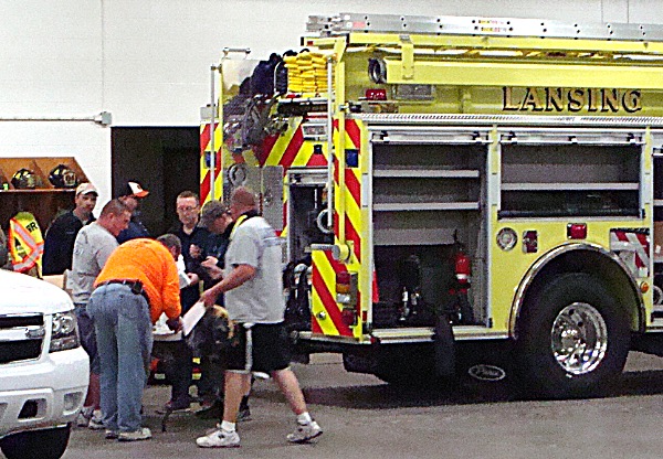 Volunteer firefighters prepare equipment for Pumper 1101 Tuesday evening 1101