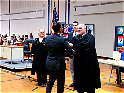 Tompkins County Clerk Maureen Reynolds, CIS Officer Jack Phetteplace, and New York State Supreme Court Justice Eugene Faughnan congratulate new American citizens as they receive their Certificates of Naturalization nat certs