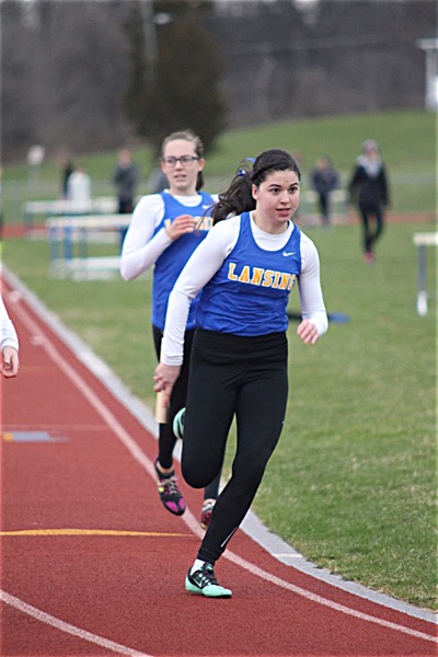 Michelle Schafer receives the baton from junior Emily Gallagher in the 400M relay. Photo by Mike Barre. tf shaffnergallagher