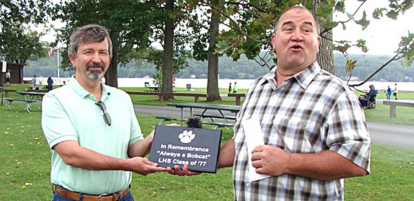 Class of '77 alumnus Michael Fenner presents a plaque and a check to Lansing Supervisor Ed LaVigne Saturday. The plaque will be mounted in concrete at the foot of the oak tree Fenner's class donated to Myers Park, and the money will be used to provide Recreation Department program scholarships. Class of '77