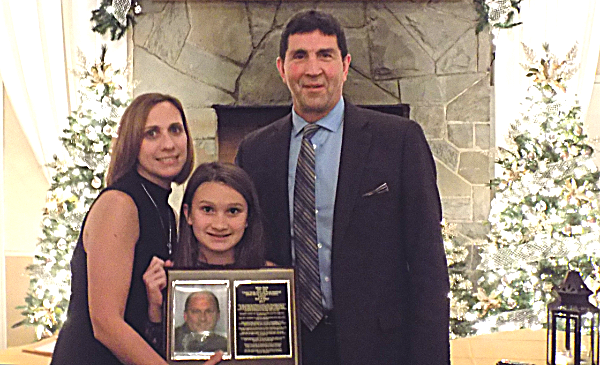 Coach Stuart Dean presents Adam Heck's plaque to wife Beth Heck, and daughter Alexis.