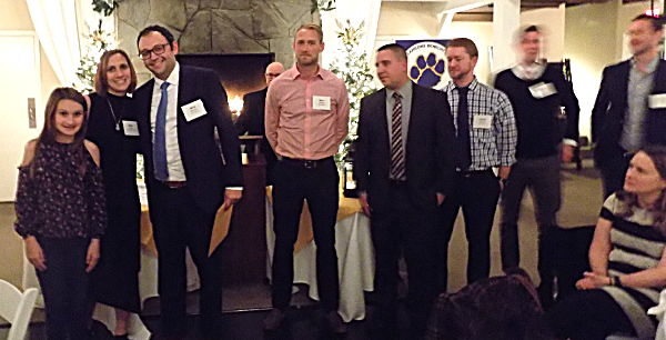 1998 Boys Soccer team members receiving envelopes from Beth Heck and daughter Madyson