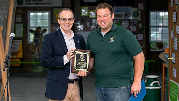 Nate Chittenden accepts the inaugural Cornell University Hometown Alumni Award from Vice President for University Relations Joel Malina June 23 at Dutch Hollow Farm. Photo by Chris Kitchen cornell Chittenden2