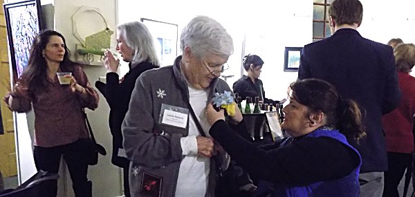 A corsage sent to Bement by Lansing's representative to the Tompkins County Legislature, Mike Sigler, is pinned on prior to the awards ceremony Louise Bement receives a corsage