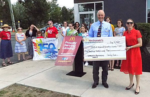 Ithaca YMCA CEO Frank Towner receives a $500 check from McDonald's owner Courtney Feehan Lansing McDonald's