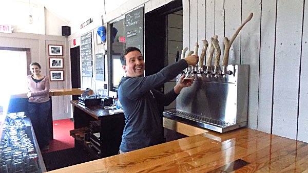 Chis fills a glass of one of eight beers on tap Tap room