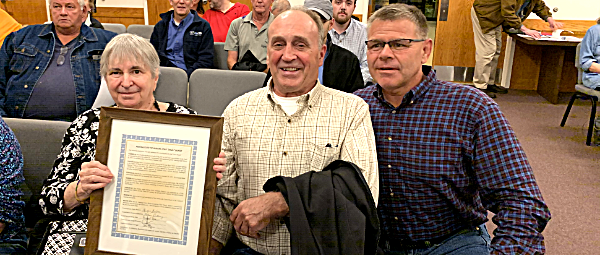 Stanley 'Stosh' Burke (center) was honored Wednesday Mary Burke (left) holds a framed resolution that was presented by Councilman Doug Dake (right) Stanley 'Stosh' Burke
