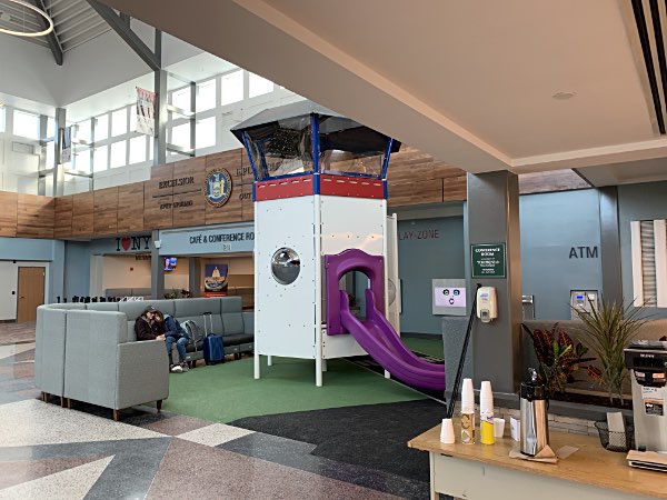 The play structure is an airport control tower. Kids can climb into the top and direct air traffic, and then slide down to the ground, a soft floor. Ithaca-Tompkins International Airport