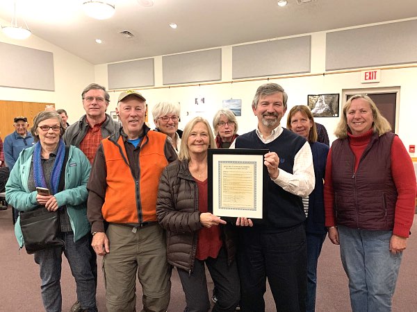 Marcia Herrick was presented with a framed copy of the resolution naming her 2019 Volunteer of the Year by Lansing Town Supervisor Ed LaVigne, and surrounded by Lansing Center Trail friends. Left to right: Deborah Trumbull, Gary Mallow, Roger Hopkins, Ruth Hopkins, Marcia Herrick, Maureen Cowan, Ed LaVigne, Susan Ruoff, Reenie Baker Sandsted Marcia Herrick