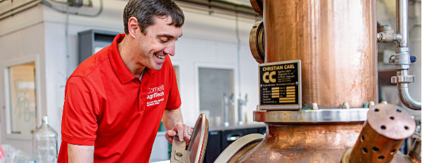 Chris Gerling, senior extension associate, checks the still located at Cornell AgriTech’s food science pilot plant in Geneva. cornell Agritech