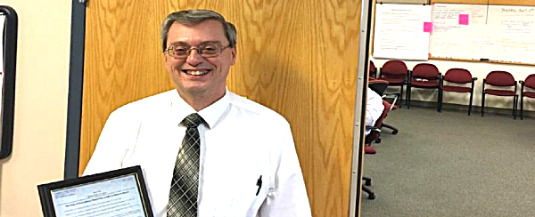 Lee Shurtleff outside the DoER conference room renamed in his honor. shurtleff conference room