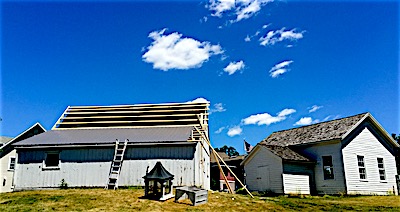 The Lansing Historical Archive building (left) sits next to the historic Field one room school house in the Lansing Town Hall campus. This week construction began on a new roof. history lha roof